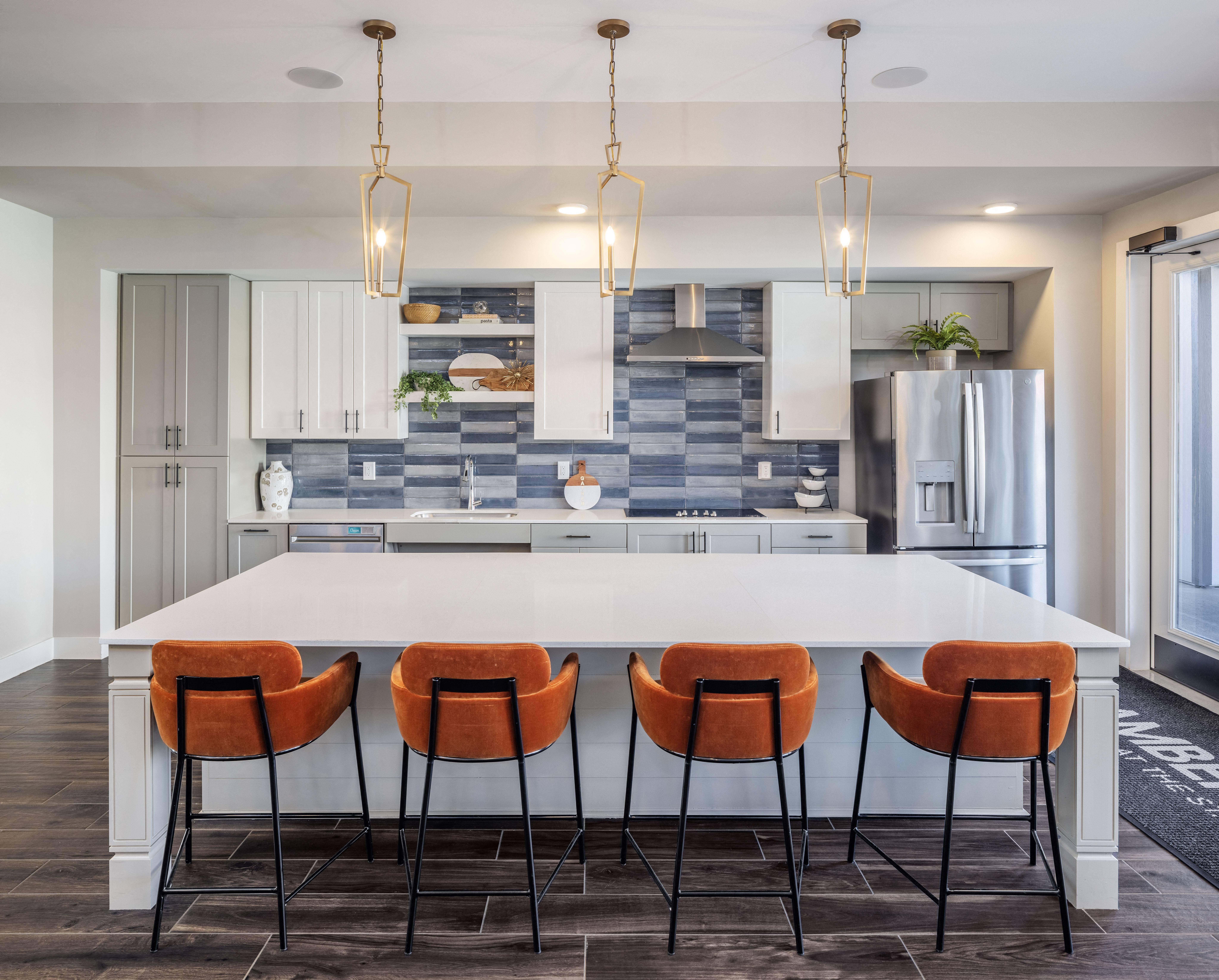 a kitchen area with an island and chairs at a senior apartment community